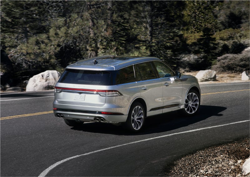 A 2023 Lincoln Aviator® Grand Touring model is shown being driven on a tight turn of a mountain road | Koons Lincoln of Bethesda in Silver Spring MD
